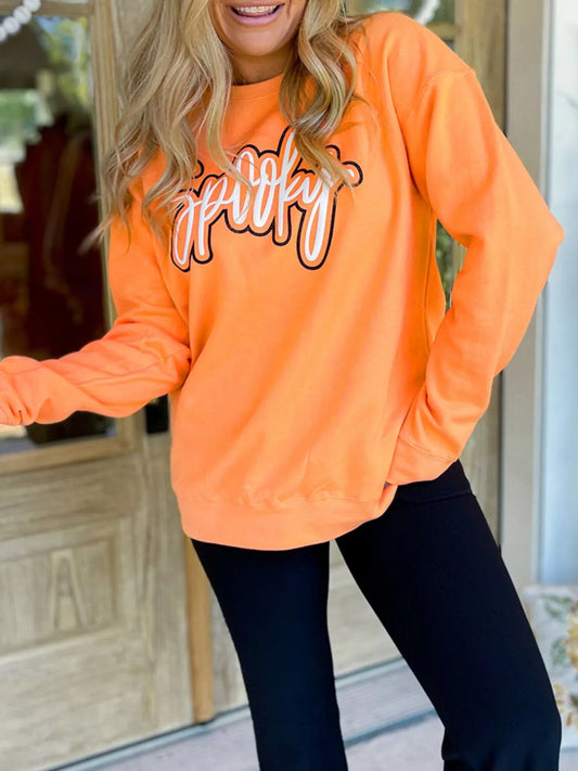 Chic Spooky Round Neck Long Sleeve Sweatshirt in vibrant orange color, featuring 'Spooky' text design, styled with black leggings.
