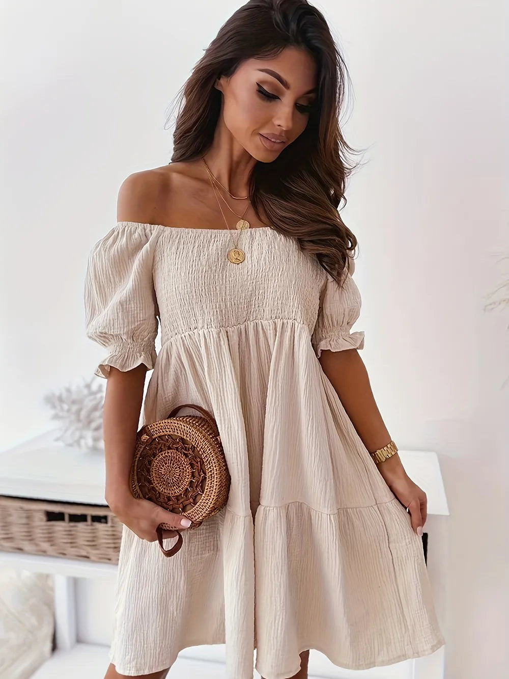 Model wearing a beige full size ruffled off-shoulder dress with short sleeves, highlighting the chic and ruched design.