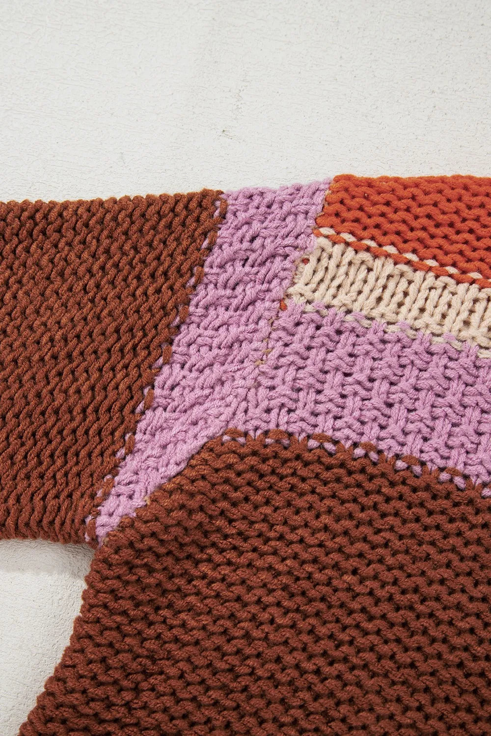 Detailed view of the shoulder seam of the Stylish Colorblock Striped Sweater with Round Neck, featuring a rich blend of earthy tones and a unique knit texture, ideal for a trendy casual look.