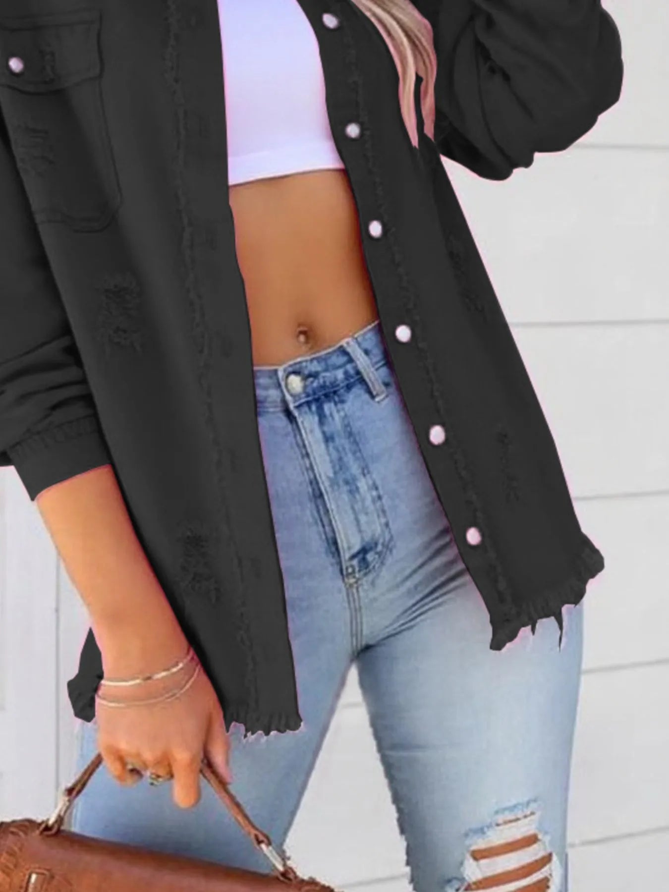 Contemporary oversized distressed denim jacket with frayed edges and buttoned pockets, seen in black, perfect for elevating any casual ensemble.