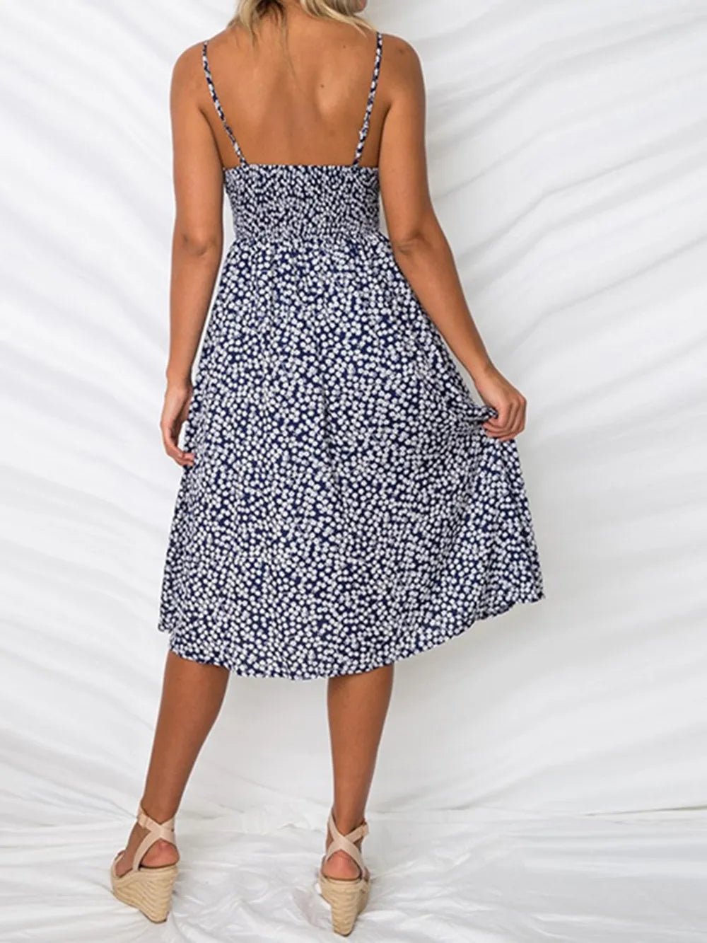 Back view of the Cutout Smocked Sweetheart Neck Cami Dress with Decorative Button and Opaque Design in navy blue, highlighting the smocked design and floral pattern.