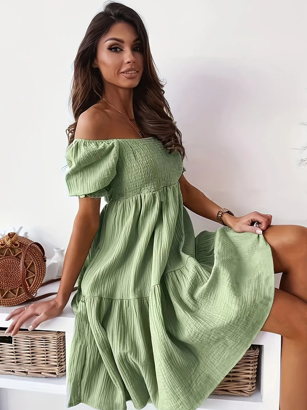 Side view of a model in a full size ruffled off-shoulder dress with short sleeves in green, highlighting the stylish and ruched design.