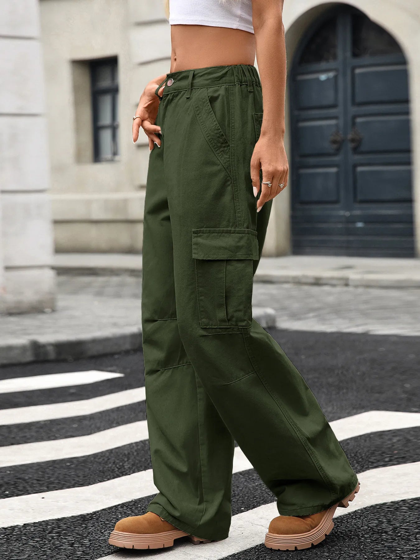 Side view of a trendy woman in green Wide Leg Cargo Jeans, highlighting the cargo pockets and relaxed fit on a city street.