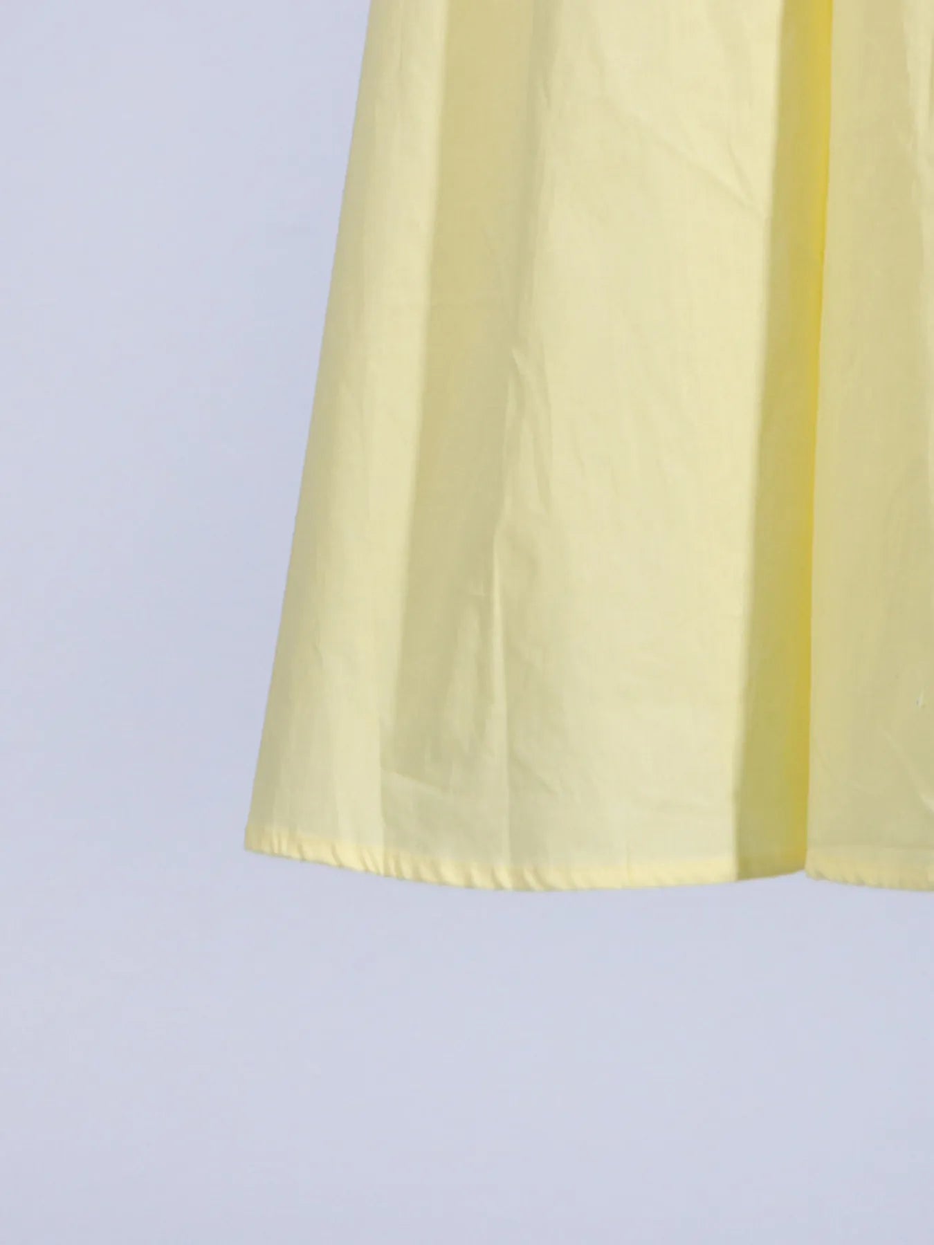 Full-length view of the trendy slit sleeveless midi dress, showcasing its flowy silhouette and chic design in bright yellow, ideal for any summer event.