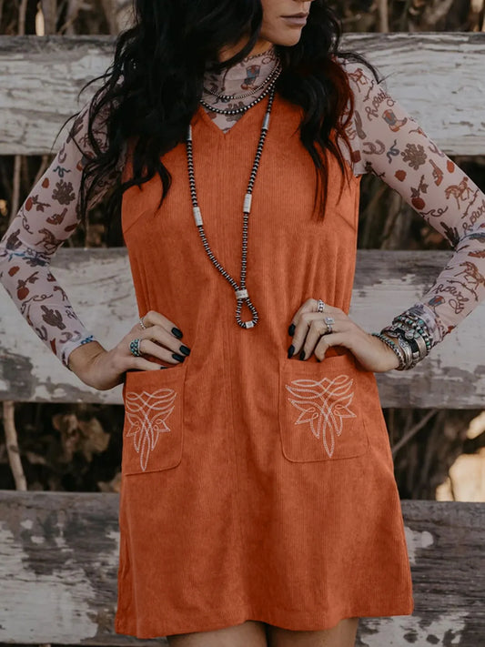 Model wearing a Corduroy Western Mini Dress With Embroidered Patch Pocket, showcasing the sleeveless and slightly stretchy design.