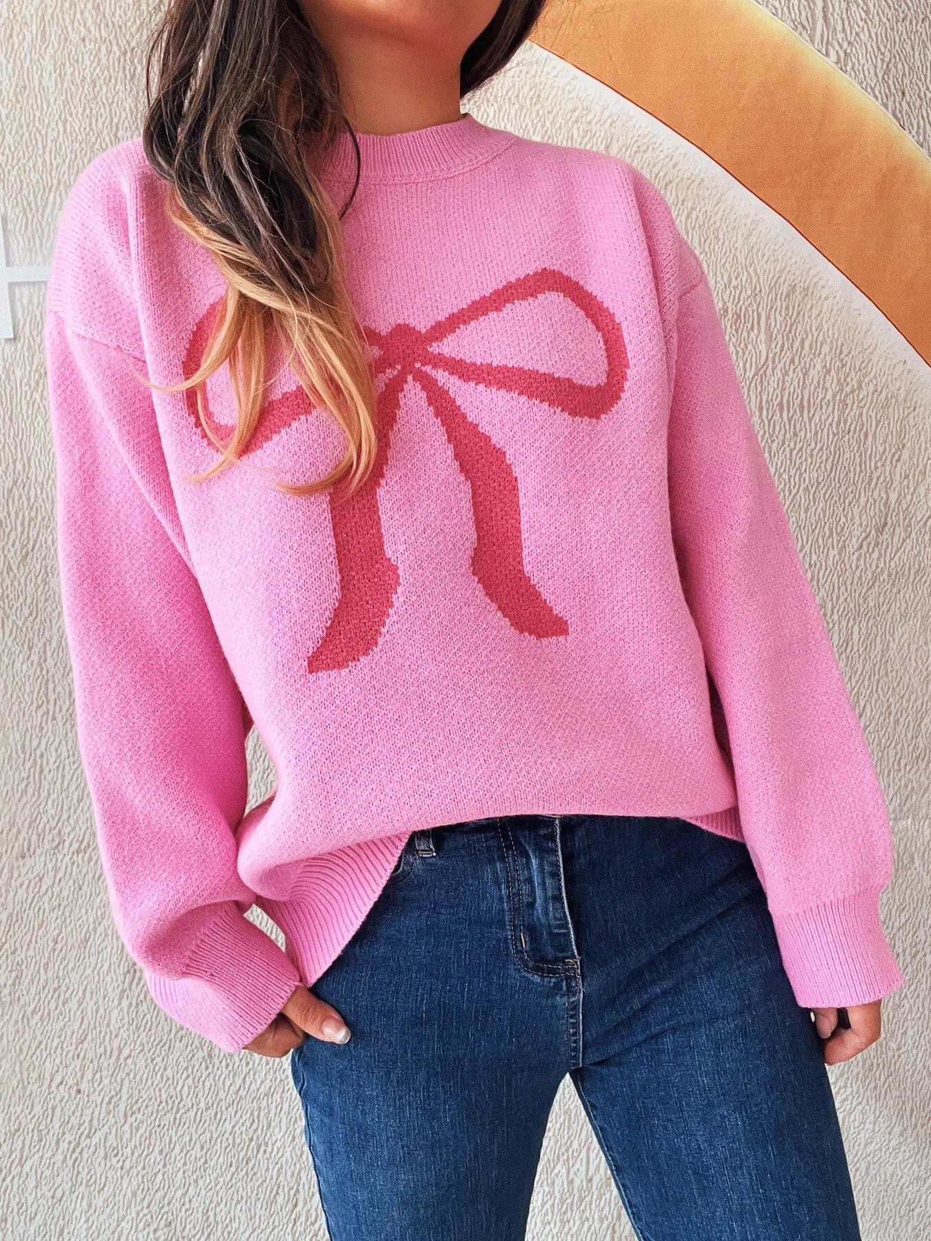 Close-up of the pink Stylish Bow Pattern Casual Long Sleeve Sweater for Effortless Everyday Wear, showcasing its cozy fabric and distinct bow pattern.