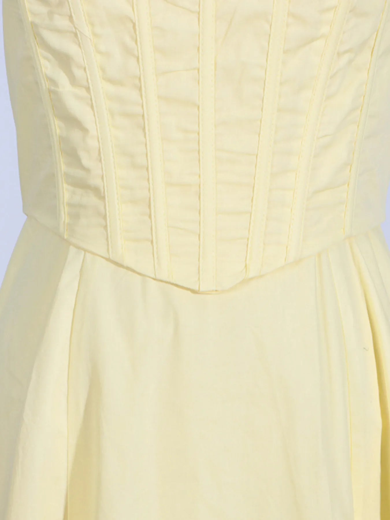 Close-up of the bodice of the Trendy Slit Sleeveless Midi Dress with Zip Back in yellow, displaying the stitching detail of the fitted bodice.