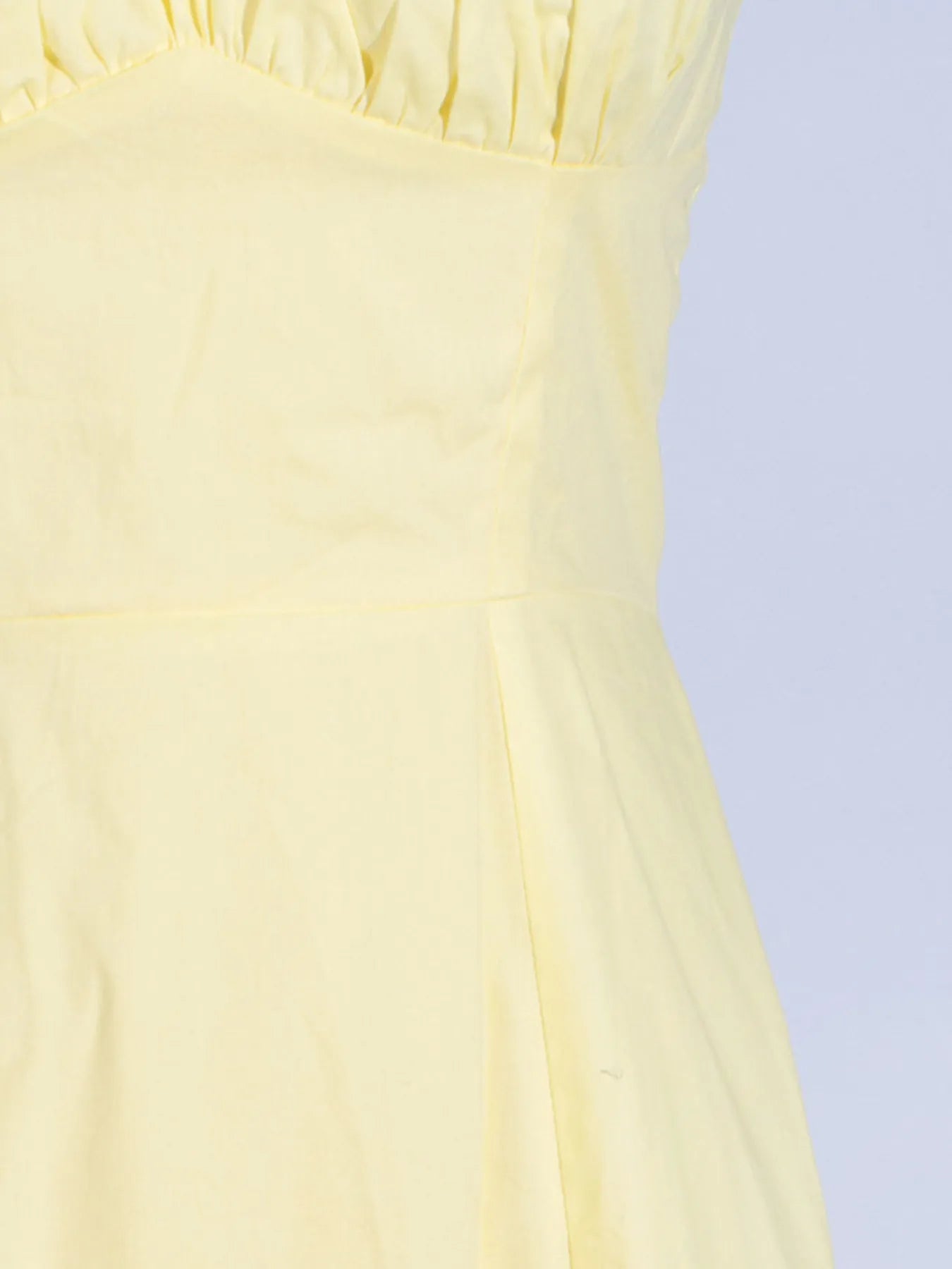 Detailed view of the frill and fabric of the Trendy Slit Sleeveless Midi Dress with Zip Back in yellow, showcasing the soft 100% polyester material.
