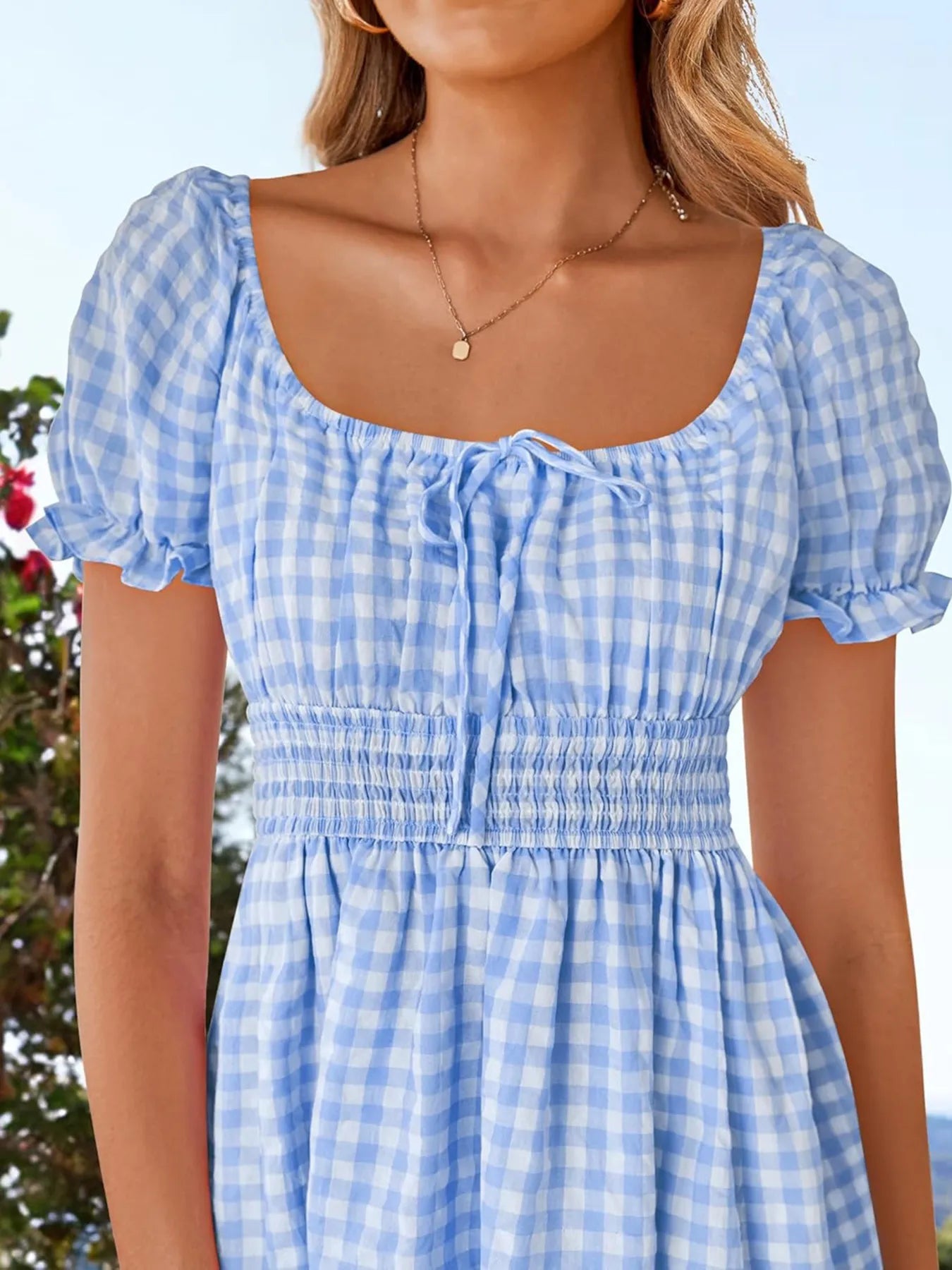 Close-up of the bodice of the Women's Gingham Puff Sleeve Smocked Dress, highlighting its smocked detail and charming puff sleeves in a lovely blue gingham.