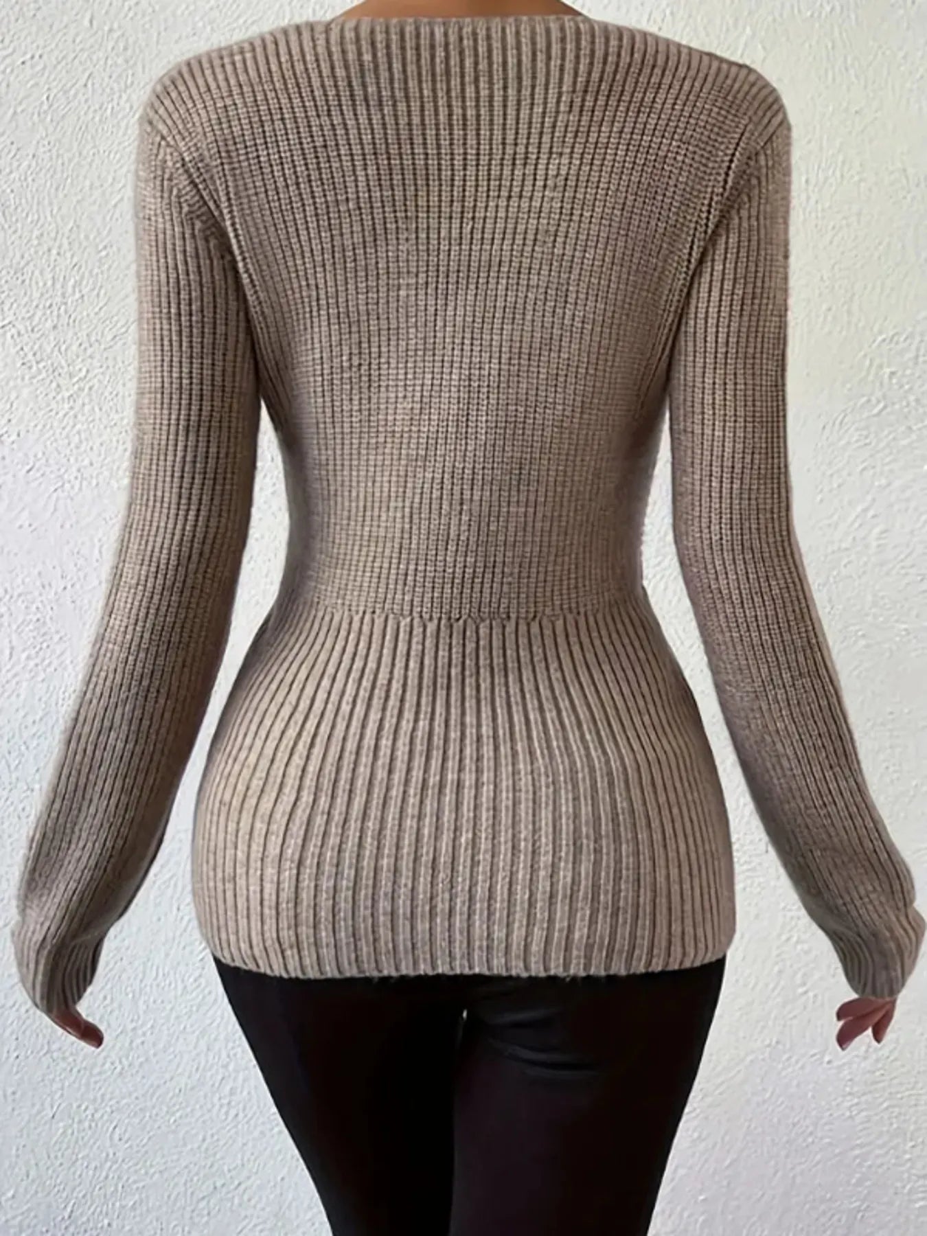 Back view of the Sleek Ribbed V-Neck Knit Top with Twist Front Detail, revealing the fitted ribbed design in stylish beige, ideal for a streamlined silhouette and modern fashion statements.