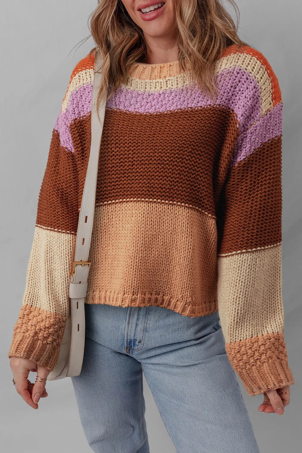 Stylish Colorblock Striped Sweater with Round Neck - Model wearing a cozy, multi-colored knit sweater, showcasing a blend of brown, purple, and cream stripes.