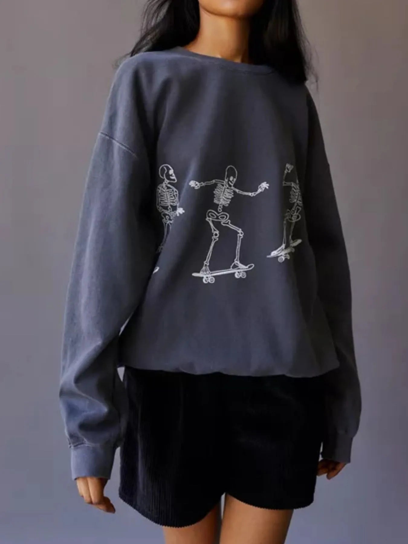 Trendy Oversized Skeleton Graphic Sweatshirt for Women showcasing a unique skeleton skating design, crafted from 100% polyester, slightly stretchy for comfort.