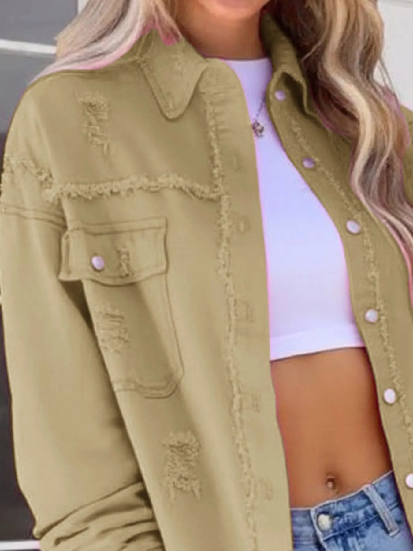 Front view of a chic oversized distressed denim jacket with frayed edges and buttoned pockets, featuring a trendy beige design.