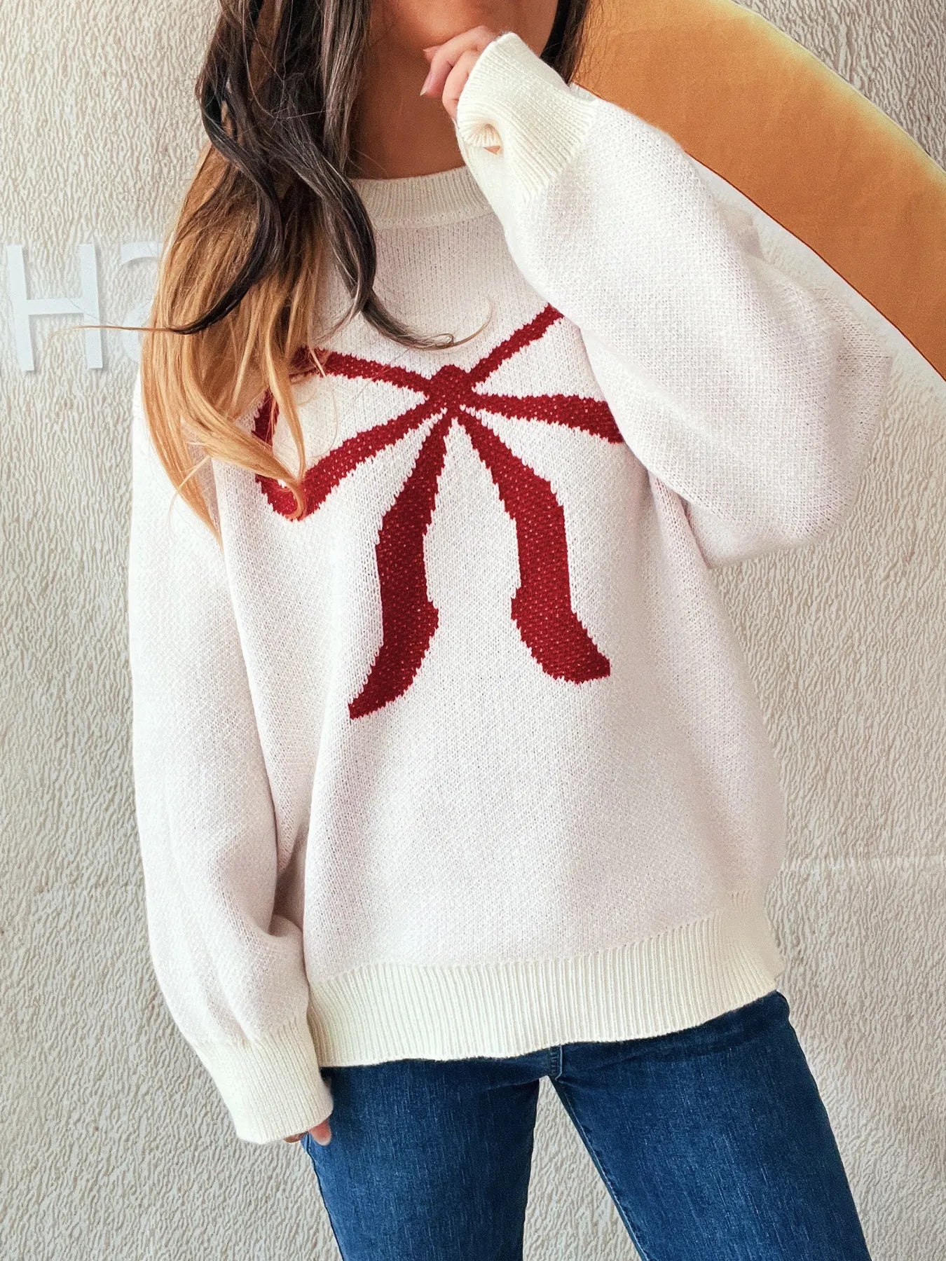 Stylish Bow Pattern Casual Long Sleeve Sweater for Effortless Everyday Wear, showcasing a red bow detail on a cozy pink sweater, paired with denim for a relaxed look.