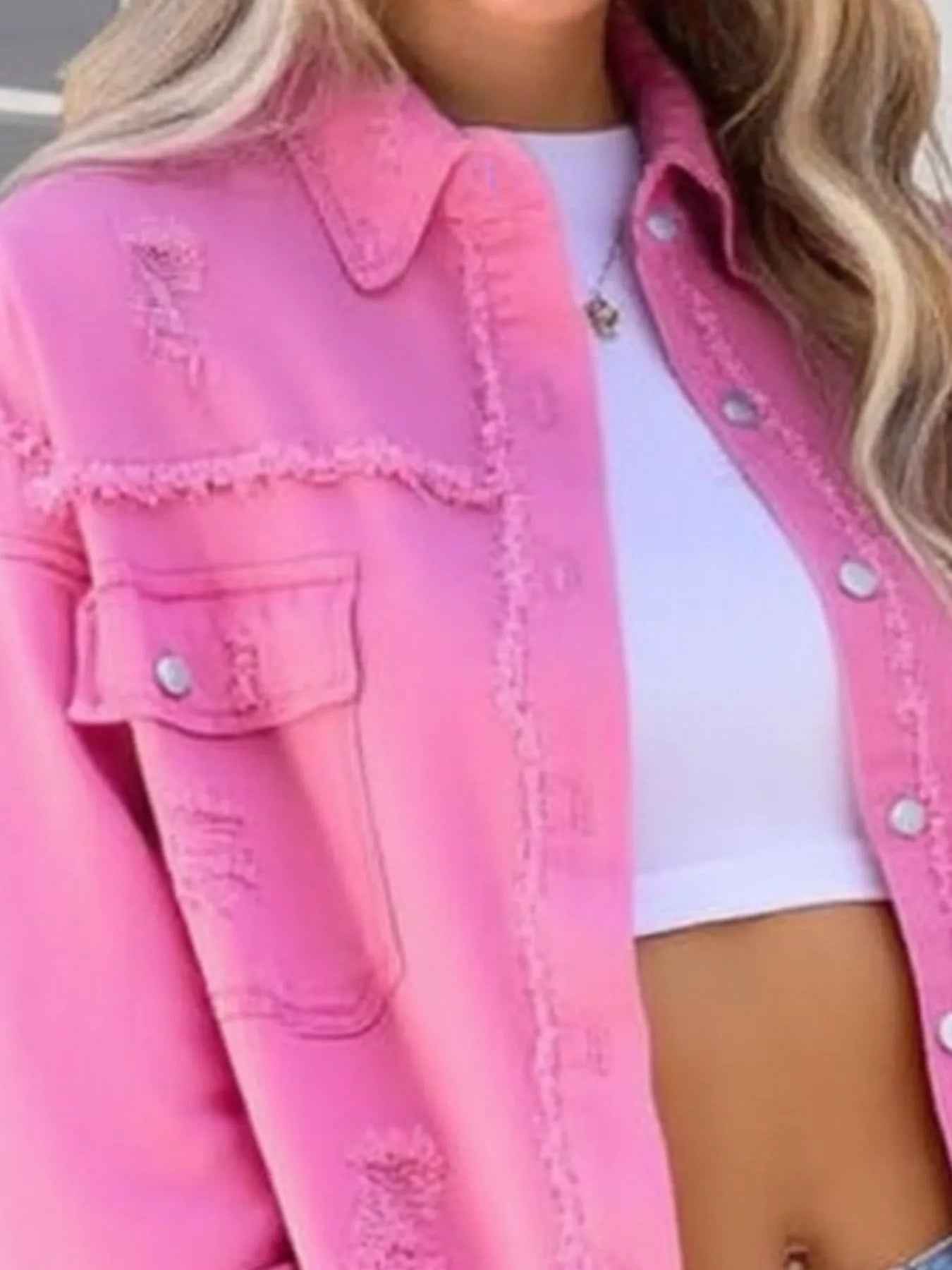 Trendy oversized distressed denim jacket with frayed edges and buttoned pockets, showcased in vibrant pink, perfect for casual outfits.