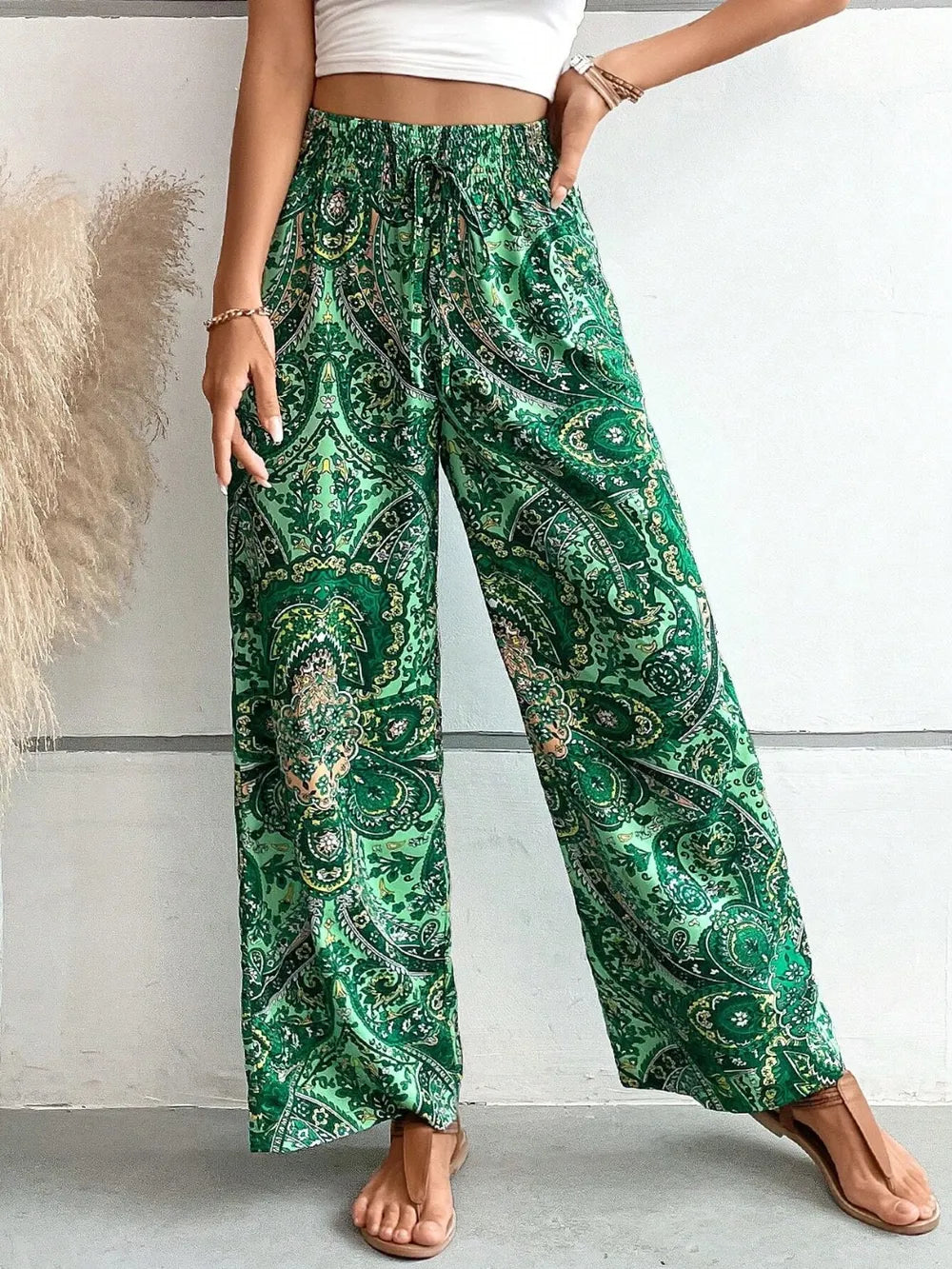 Close-up of the Trendy Printed Wide Leg Pants with Tied Detail, showcasing the intricate green paisley pattern and 100% opaque polyester material for a stylish look.
