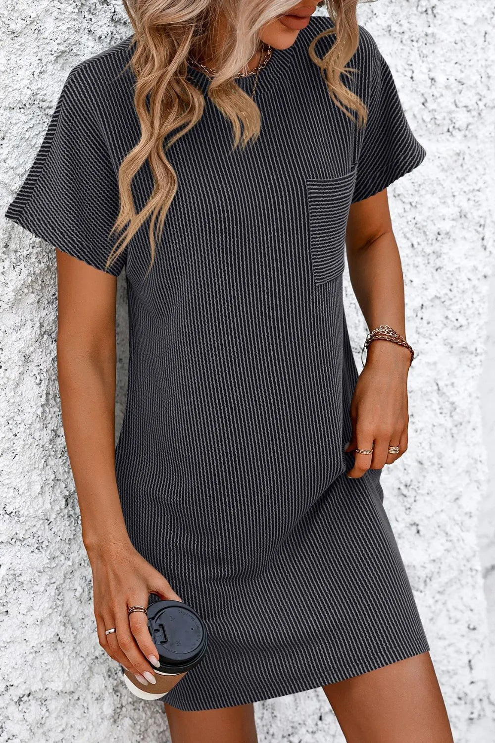 Close-up of Mandy Ribbed Striped Mini Tee Dress with Pockets in black, emphasizing its ribbed texture and stylish features.