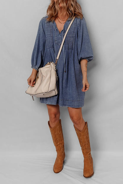 Chic model displaying a Tie Neck Long Sleeve Mini Denim Dress paired with trendy ankle boots, ideal for a stylish daytime look.