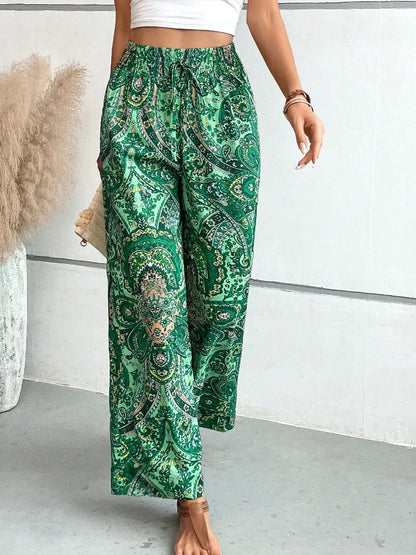 Trendy Printed Wide Leg Pants with Tied Detail captured in motion, highlighting the soft and flowy fabric in a beautiful green paisley pattern, ideal for style and comfort.
