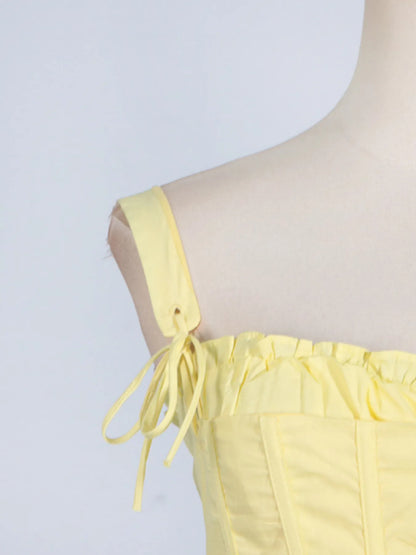 Side view of the trendy slit sleeveless midi dress with tie detail at the shoulder, perfect for adding a stylish touch to your wardrobe in striking yellow.