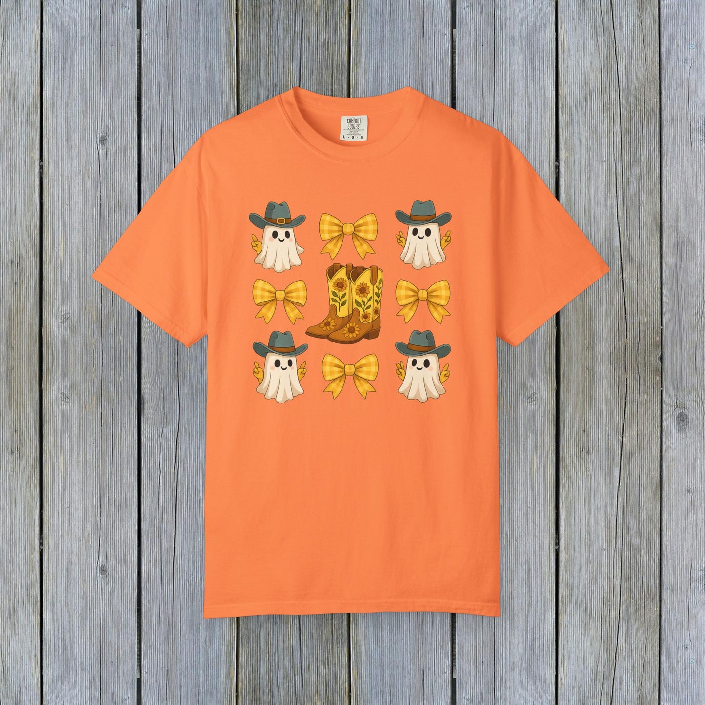 Cute Halloween T-Shirt in vibrant orange with playful ghost graphics, cowboy boots, and bows, representing unisex fall fashion made from eco-friendly fabric.