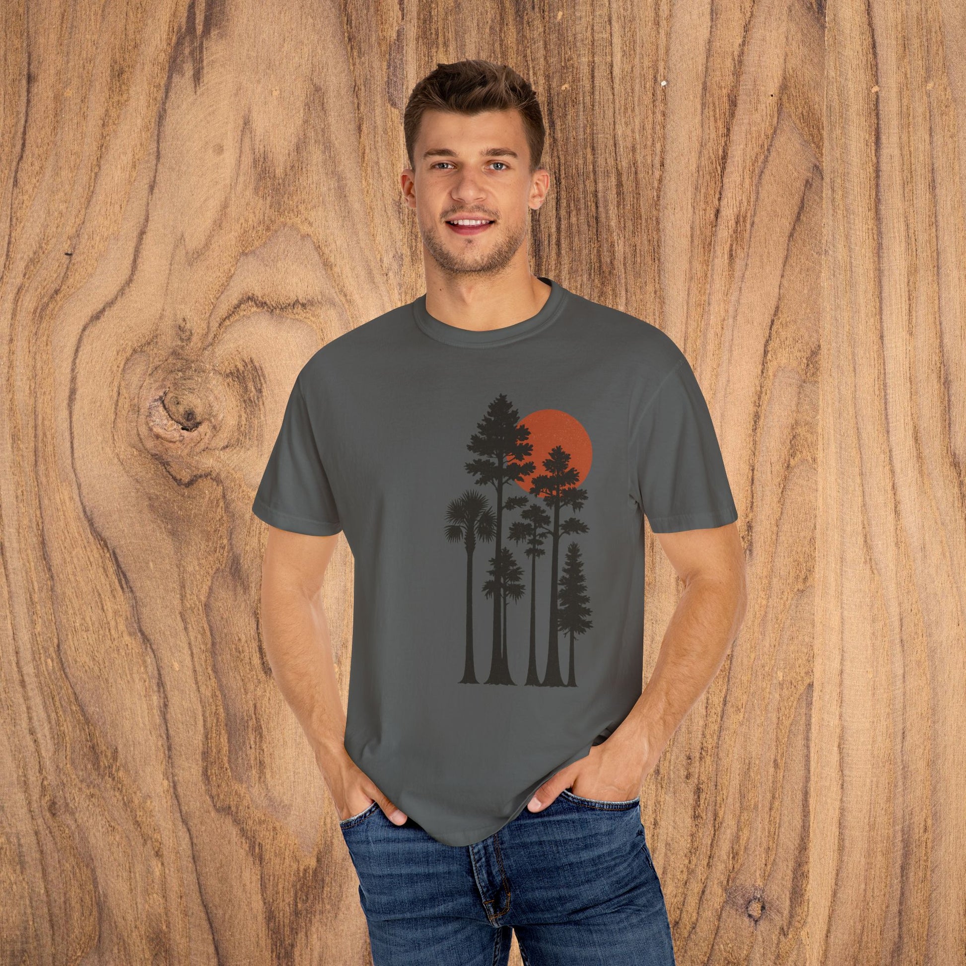 Model posing in Sunset Trees Unisex T-Shirt in gray, featuring a scenic sunset design perfect for nature lovers and casual wear.