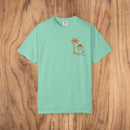 Unisex Sunset Palm Tree T-Shirt in mint green, made from vibrant garment-dyed cotton, showcasing a stylish palm tree design, available in 58 colors.