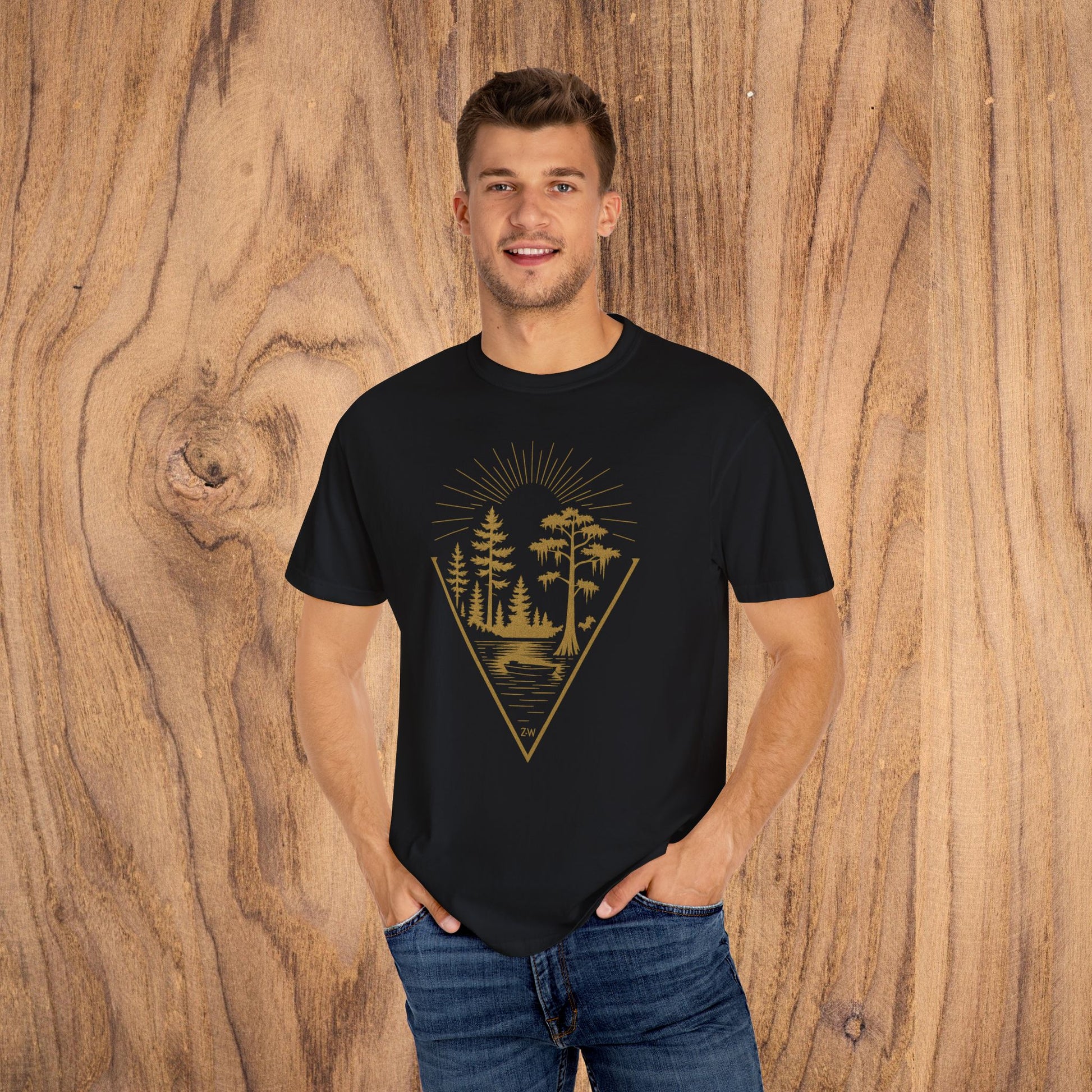 Nature Outdoor Vibes Tee featuring a model in a black t-shirt with a gold forest graphic, perfect for outdoor enthusiasts, made from soft 100% US cotton for durability and comfort.