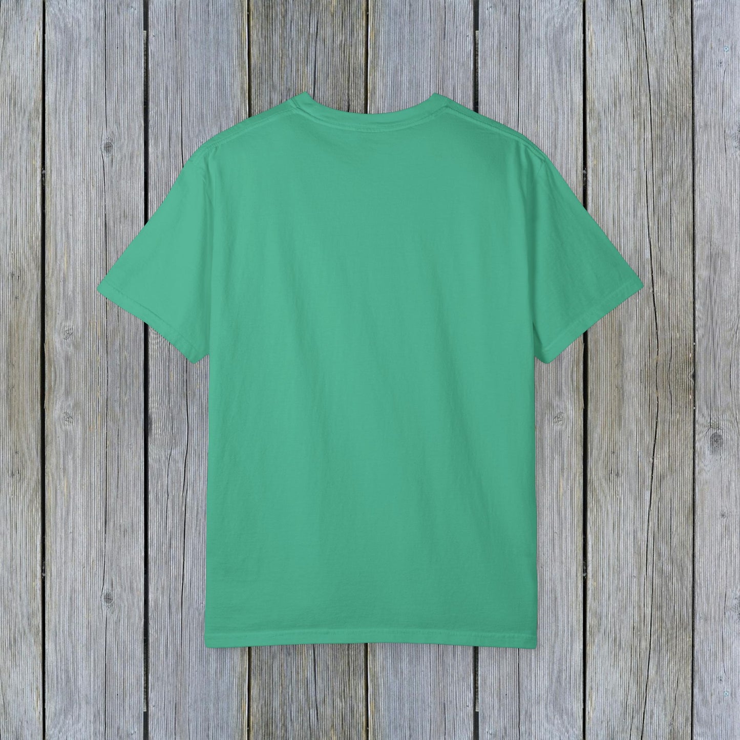 Back view of Unisex Garment-Dyed Lake Rules Tee in vibrant green on a weathered wooden background, showcasing the soft vintage fabric ideal for outdoor activities.