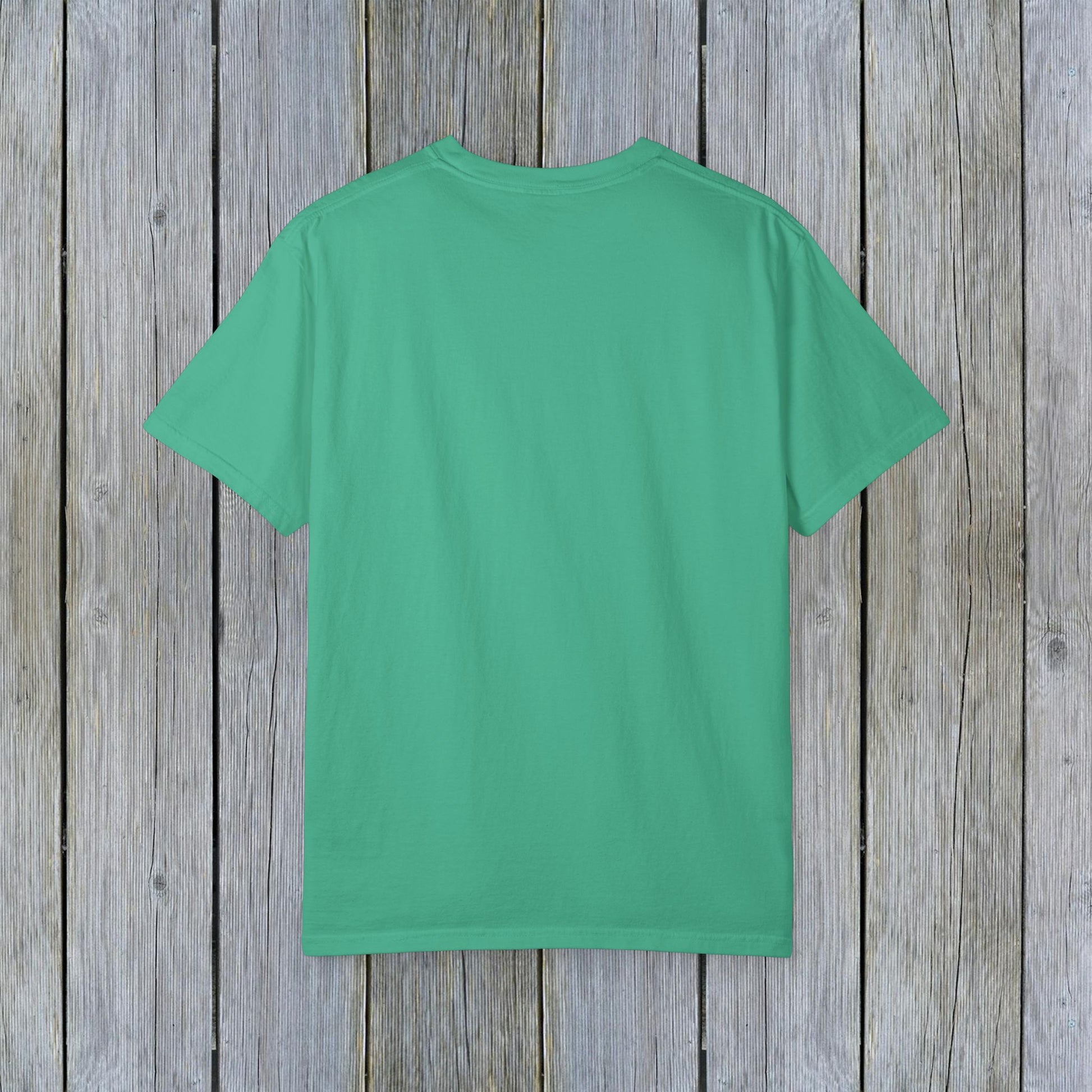 Back view of Unisex Garment-Dyed Lake Rules Tee in vibrant green on a weathered wooden background, showcasing the soft vintage fabric ideal for outdoor activities.