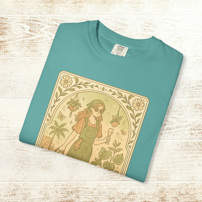 Rooted One Tarot Tee in soft aqua color featuring a delightful design of a woman amidst plants and butterflies - ethically sourced cotton, available in sizes S-4XL.