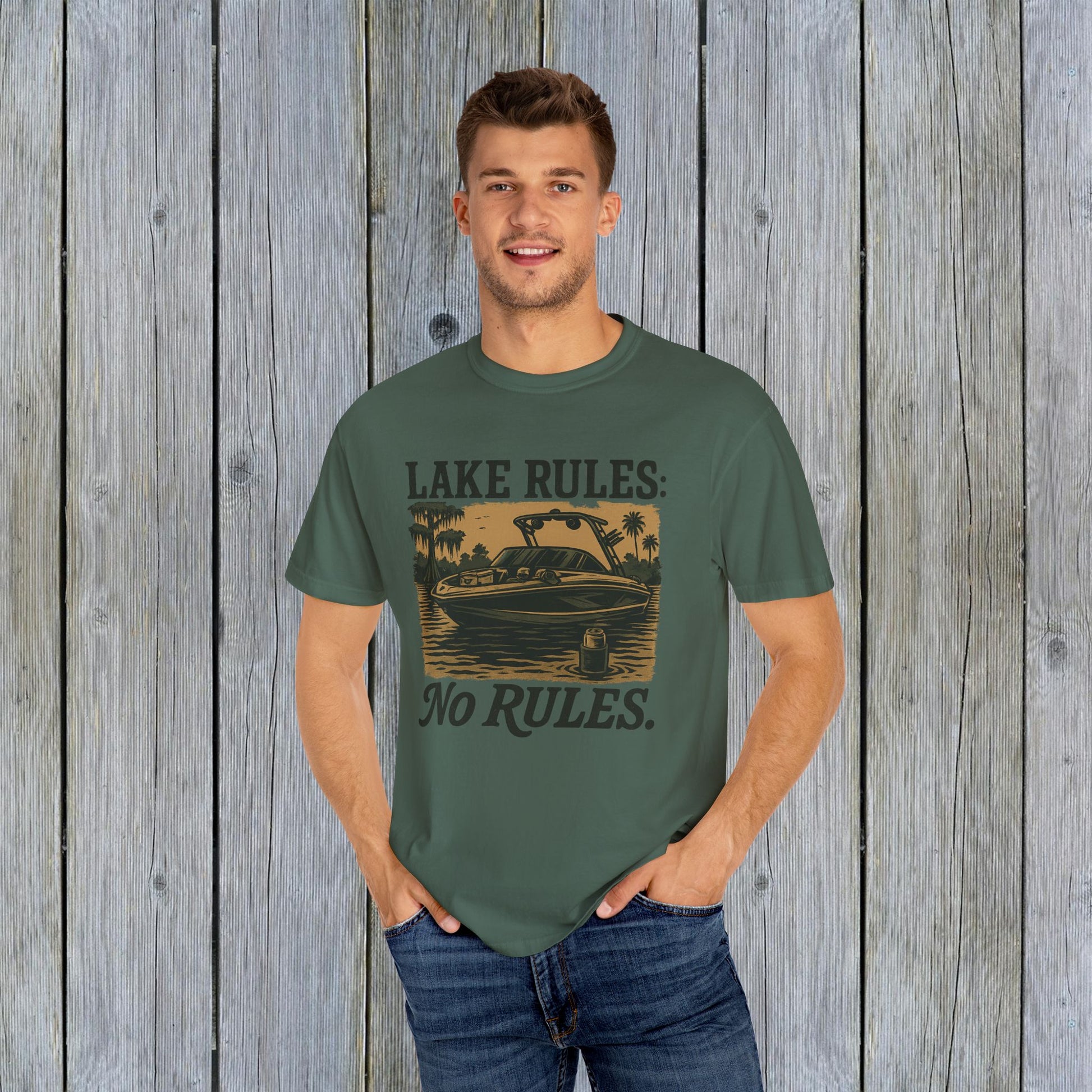 Casual wear featuring a man in a green Unisex Garment-Dyed Lake Rules Tee, highlighting the boat design, ideal for summer outings.
