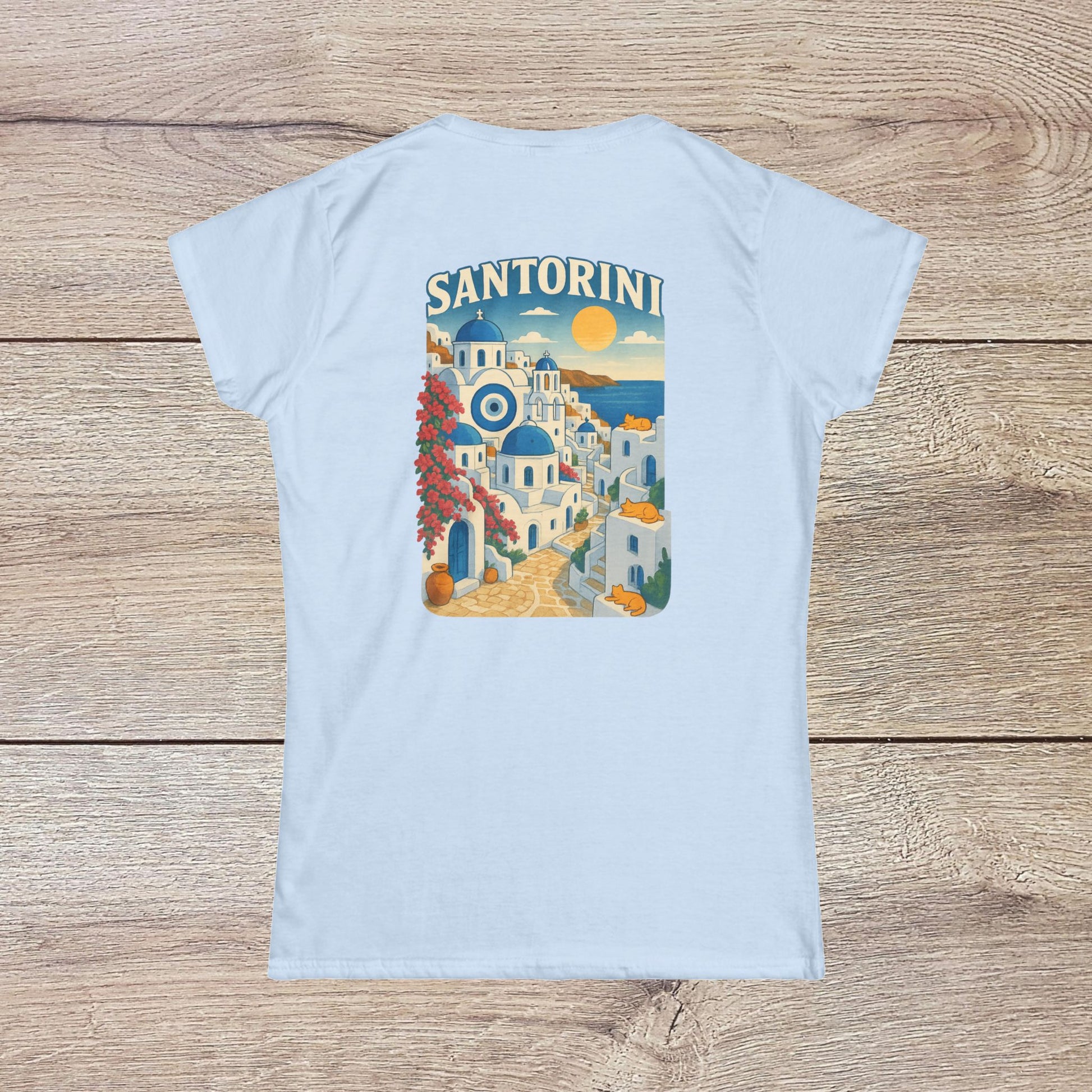 Santorini Tee in light blue with an artistic depiction of Santorini’s landscape on the back, crafted for comfort from 100% eco-friendly ring-spun cotton.