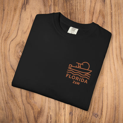 Unisex Florida Graphic Tee in black color, designed with a chic boating graphic. Crafted from soft, garment-dyed US cotton, this tee combines style and comfort, available in sizes S-4XL.