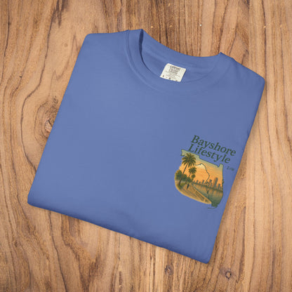 Detail shot of the Bayshore Lifestyle Tee folded neatly, showing the vibrant blue color and elegant palm tree design on the left chest.