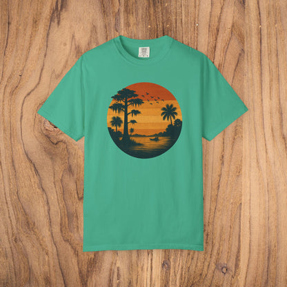 Unisex Garment-Dyed Sunset Tee in bright teal displaying a sunset scene with palm trees, a stylish choice for casual gatherings.