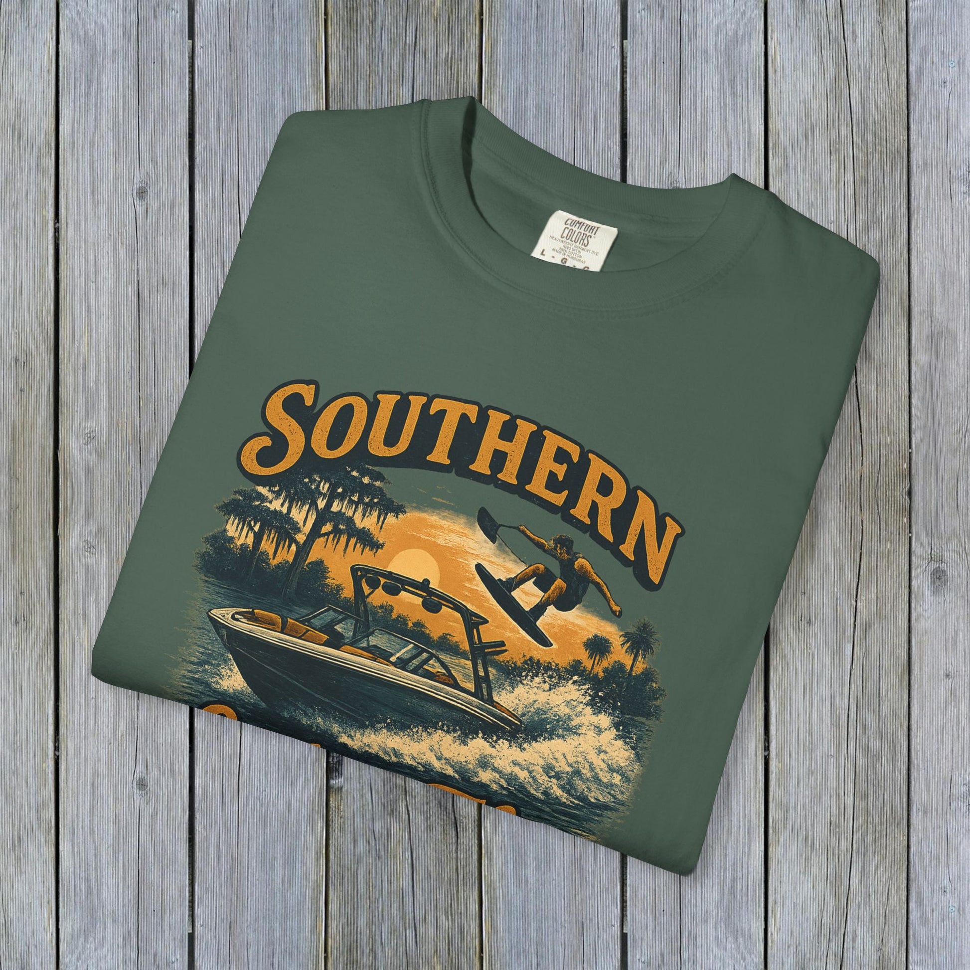 Southern Lake Flow T-Shirt laid flat in olive green, highlighting its unique, eco-friendly design with nautical theme, made of 100% US cotton for comfort.