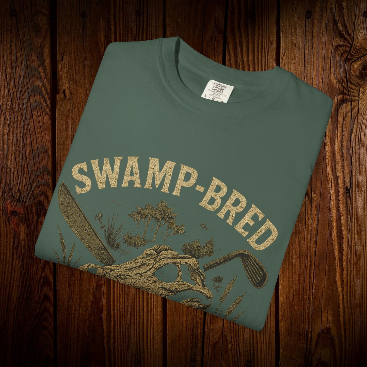Unisex Swamp-Bred Fairway-Fed Tee in earthy green color, showcasing a stylish printed design on high-quality fabric, perfect for casual wear.