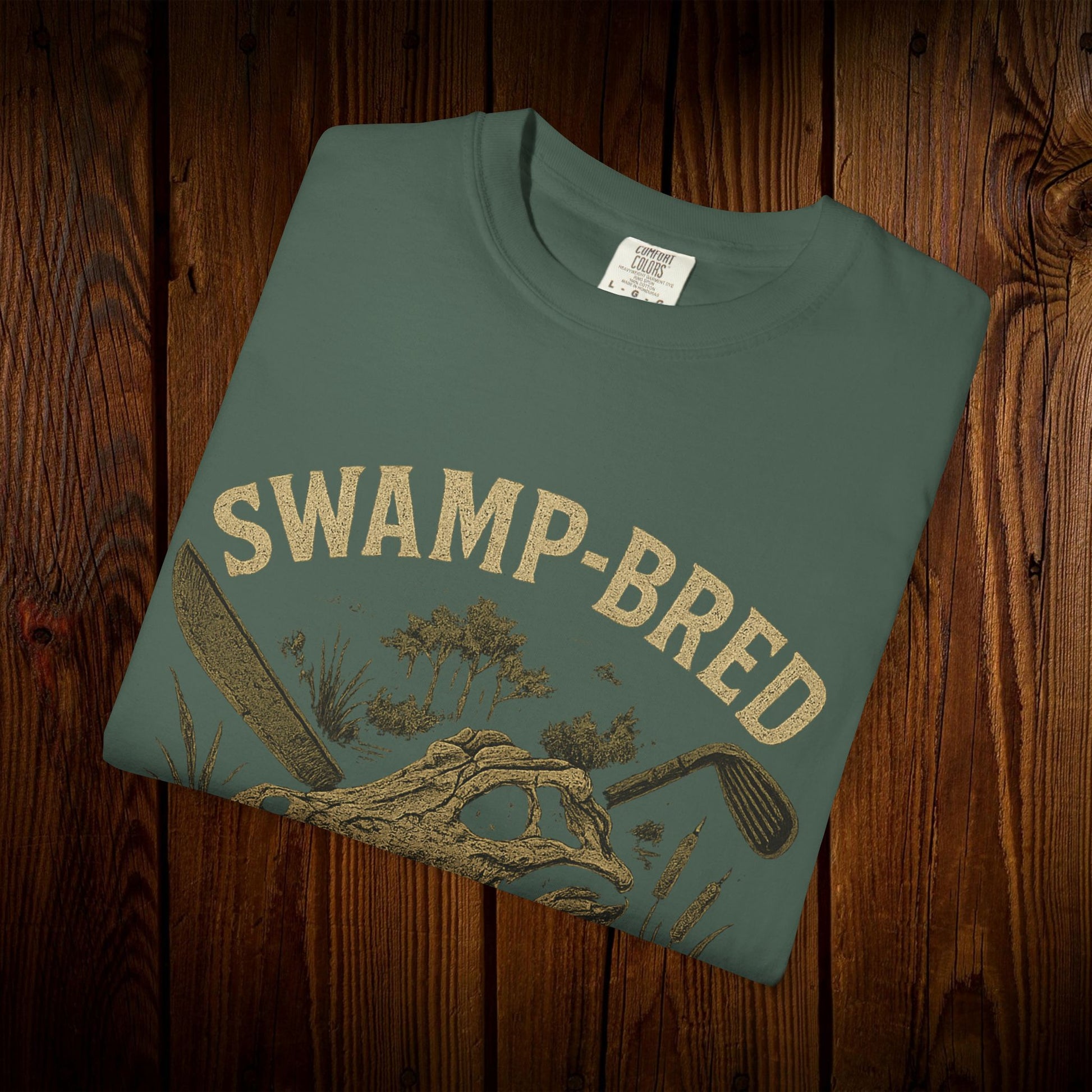 Unisex Swamp-Bred Fairway-Fed Tee in earthy green color, showcasing a stylish printed design on high-quality fabric, perfect for casual wear.
