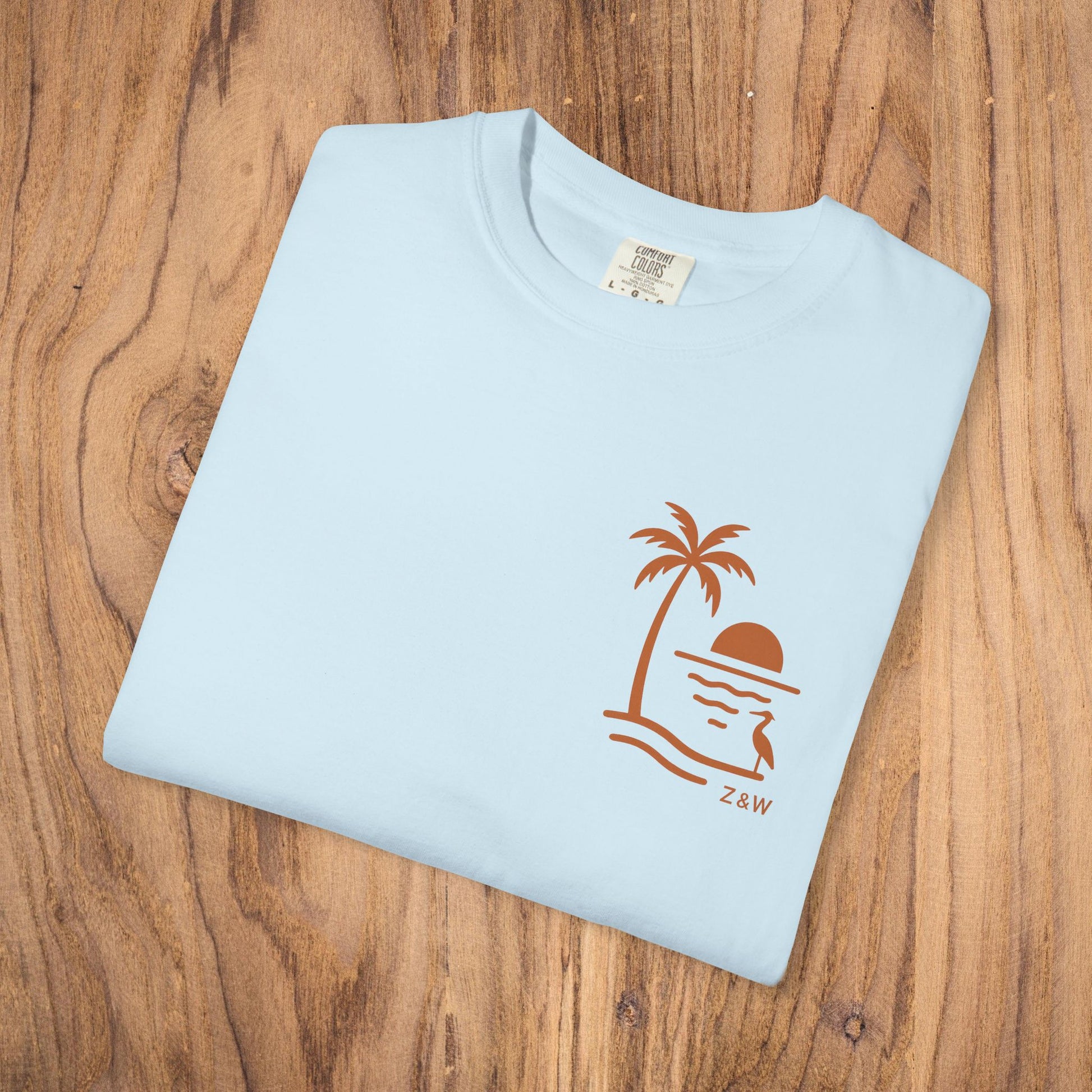 Unisex Sunset Palm Tree T-Shirt - Vibrant Garment-Dyed Cotton Tee for Men & Women in Light Blue featuring a unique palm tree and sunset graphic.