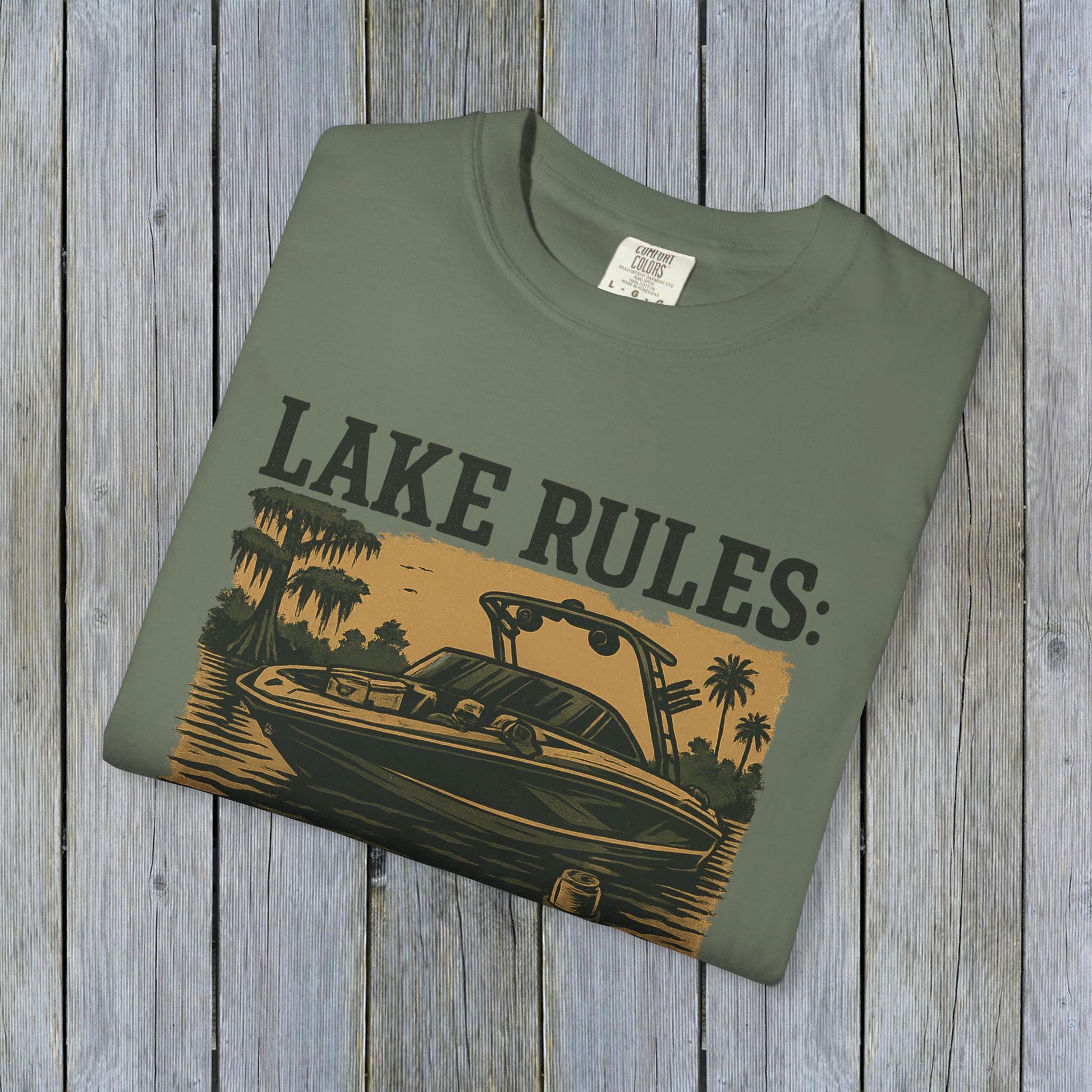 Front view of Unisex Garment-Dyed Lake Rules Tee in green showcasing a boat illustration with 'Lake Rules:' text, made from soft vintage fabric.