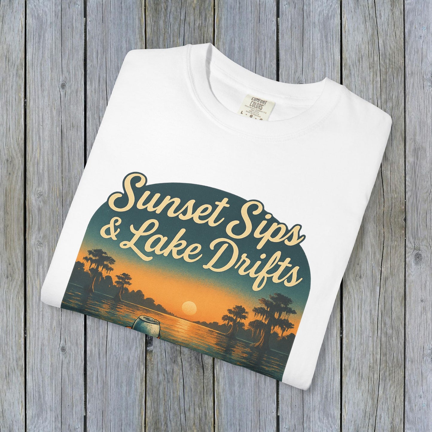 Folded Lake Drifts T-Shirt in white featuring a colorful sunset and lake scene graphic, ideal for a relaxed summer look.