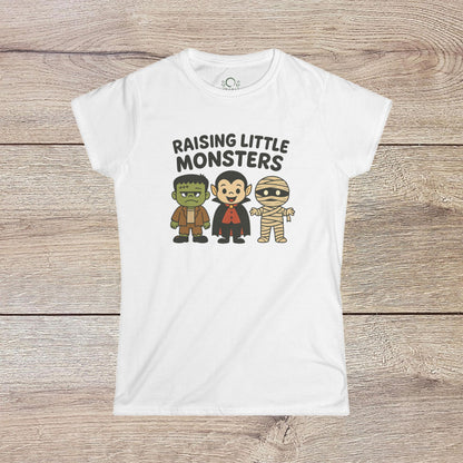 Halloween Family T-Shirt featuring cute cartoon characters, including a Frankenstein monster, Dracula, and a mummy, with the text 'Raising Little Monsters'. Perfect kids tee for parties and costumes.