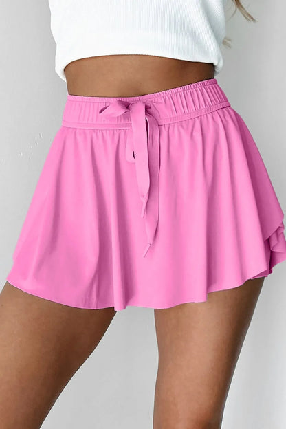 Front view of the Drawstring High Waist Lined Active Skorts in pink, showcasing the flattering fit and playful flared hem.