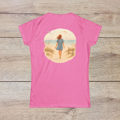 Back view of a woman walking along the beach in a pink Women's Coastal Spirit Midweight Cotton Tee, capturing the essence of coastal living and casual style.