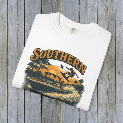 Southern Lake Flow T-Shirt featuring a stunning graphic design of a wakeboarder and boat on a lake, showcasing eco-friendly 100% US cotton material, ideal for outdoor enthusiasts.