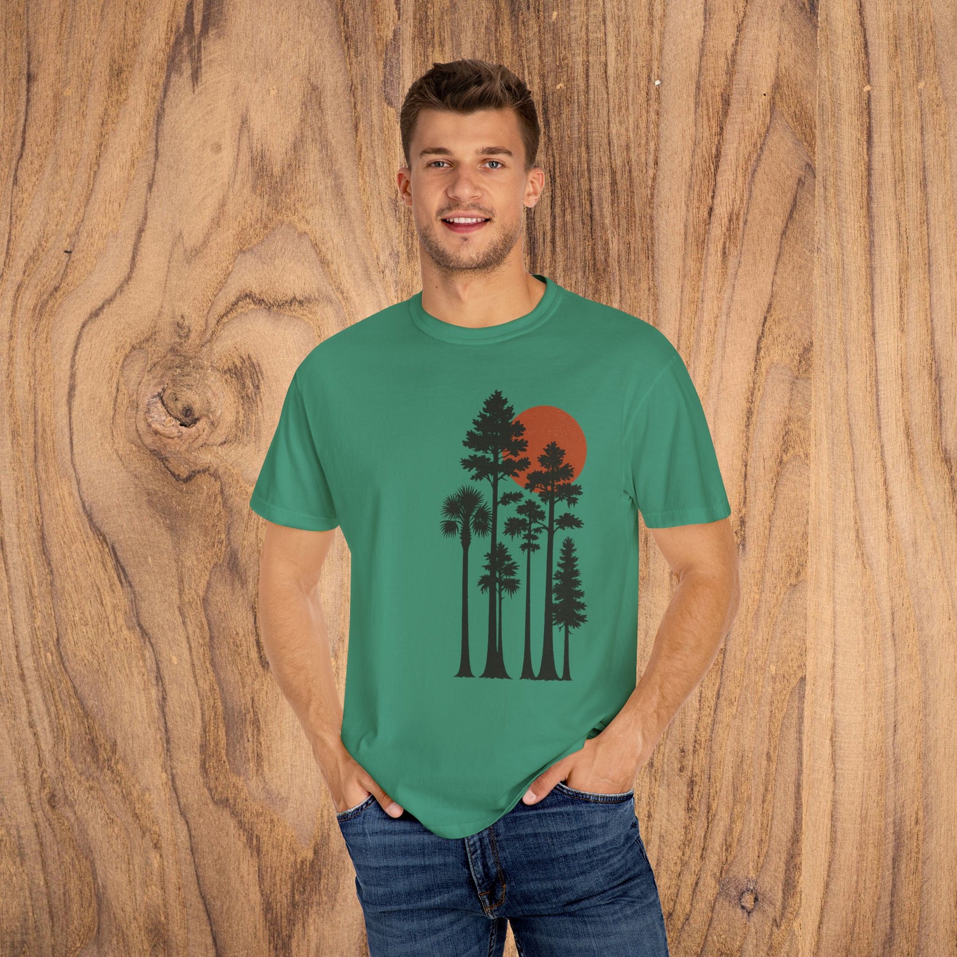 Model wearing the Sunset Trees Unisex T-Shirt in green, showcasing its comfortable fit and sunset tree design, perfect for nature enthusiasts.