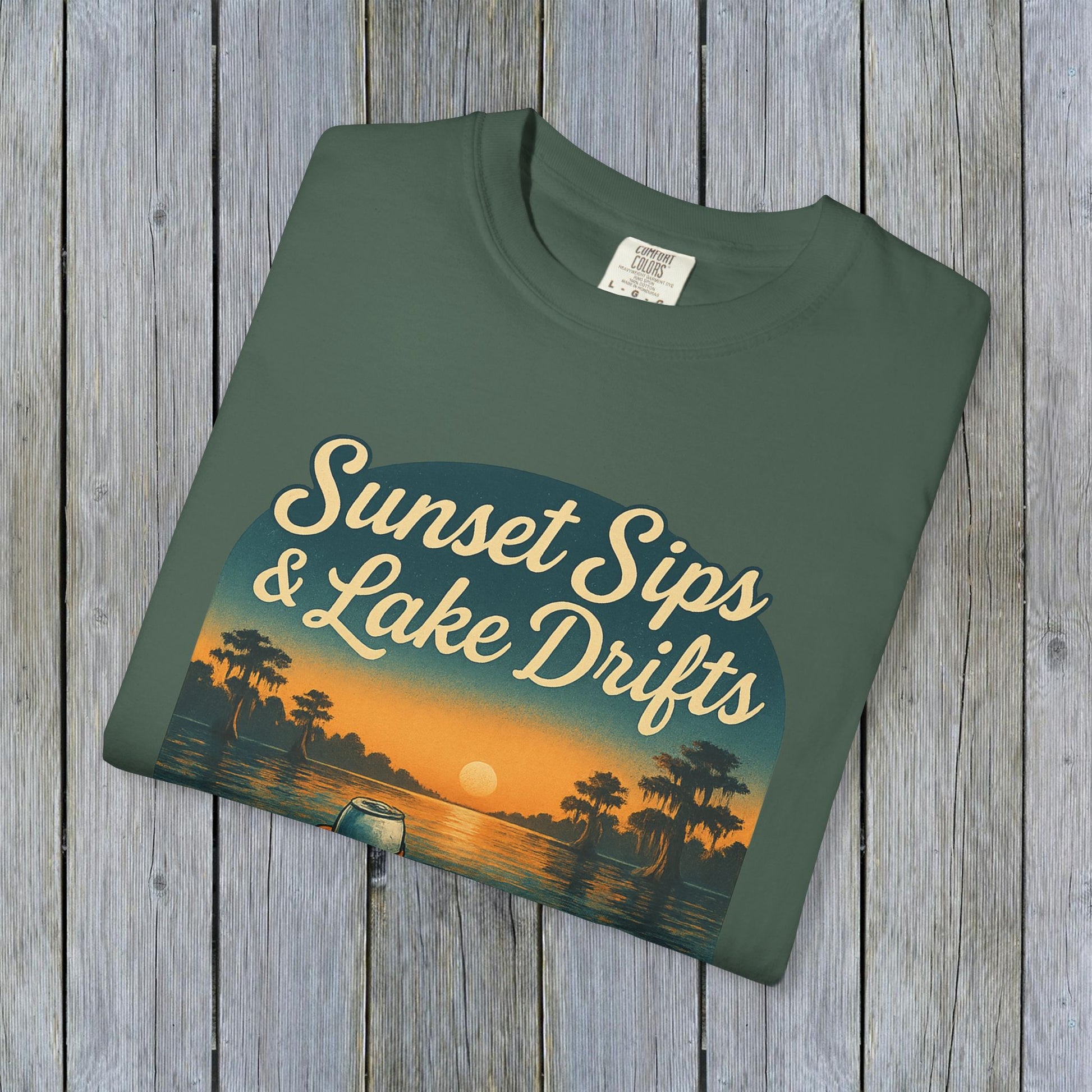 Flat lay of Lake Drifts T-Shirt in army green color, highlighting its stylish sunset and lake illustration, ideal for outdoor wear.