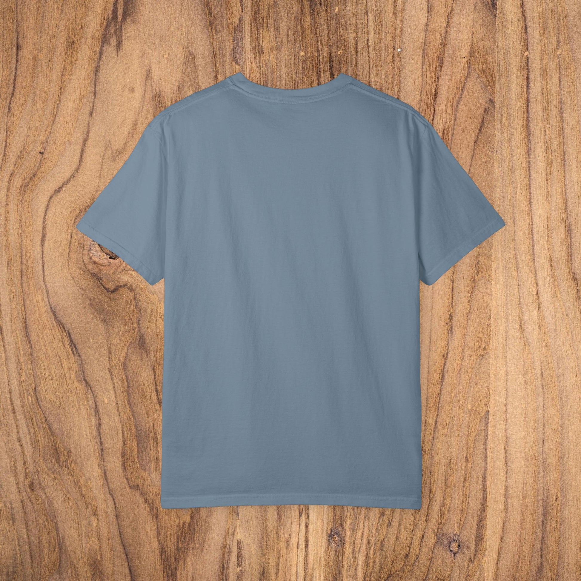 Back view of Country Club Cowboy Graphic Tee on rustic wooden background, showcasing its spacious and minimalist design.