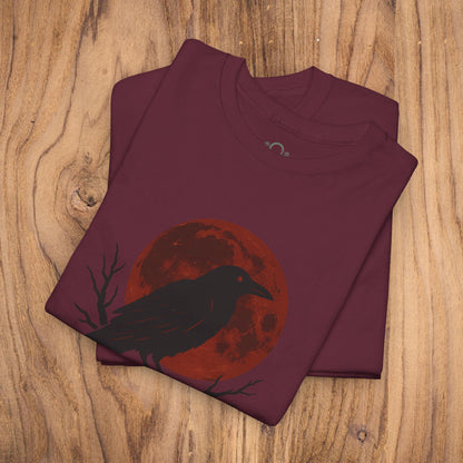 Gothic Raven T-Shirt showcasing a raven silhouette with a red moon backdrop, making it an ideal spooky gift for Halloween. Heavy cotton material and perfect for casual fall fashion.